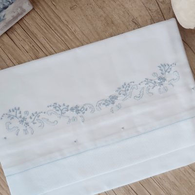Cueiro lençol de xixi bordado á mão floral azul com viés azul.